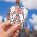 Disney Minnie Mouse Castle Waterproof Disney Laptop Stickers/  Mickey, Minnie, Stitch planner stationery decal water bottle cell phone.  A sticker featuring a pink bow, Mickey Mouse ears, and a castle. The bow has polka dots, and the castle is pink and yellow. Hearts and fireworks are scattered around the ears. The design is a whimsical Disney theme.