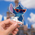 Lilo & Stitch Humor Sticker: Waterproof Vinyl Decal Hydroflask Journal .  A blue Stitch sticker adult humor with red sunglasses and a newspaper. The sticker has the phrase 'silently judging' in a red, star-framed font. The background shows a blurred image of a blue sky and disney castle. Hydro bottle sticker, weather proof.