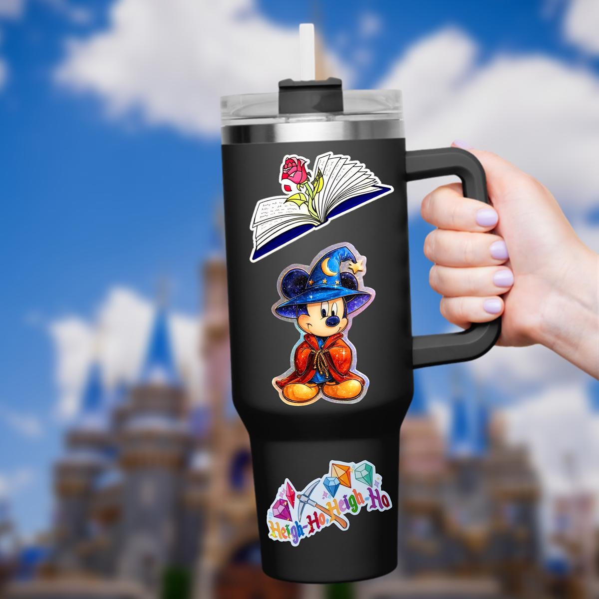 A Mickey Mouse sorcerer sticker in a wizard costume. Mickey wears a blue hat with a crescent moon and star, a red cloak, and blue shorts. The sticker has a holographic, iridescent finish, hydro bottle laptop planner decal sticker.