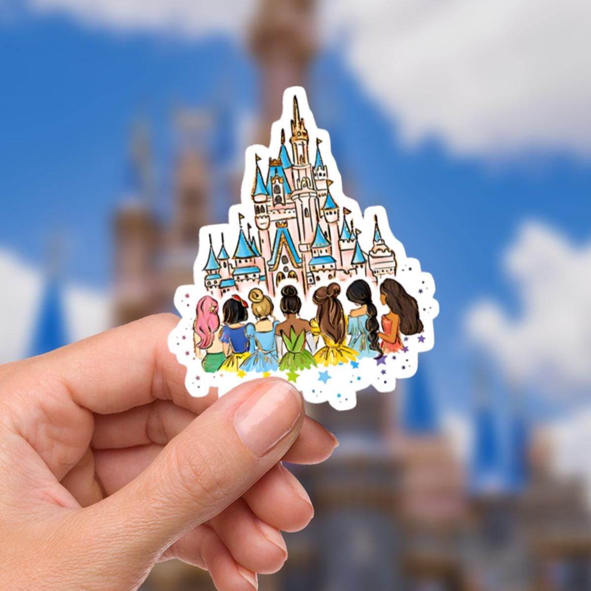 Disney Princess Castle  World Sticker Waterproof Disney Laptop, Disneying Theme Park Vacation, Castle Park Mouse featuring a whimsical illustration of a castle with blue and pink accents. In front of the castle are stylized figures of princesses with various hair colors and dress colors. The sticker has a white border with colorful star accents.