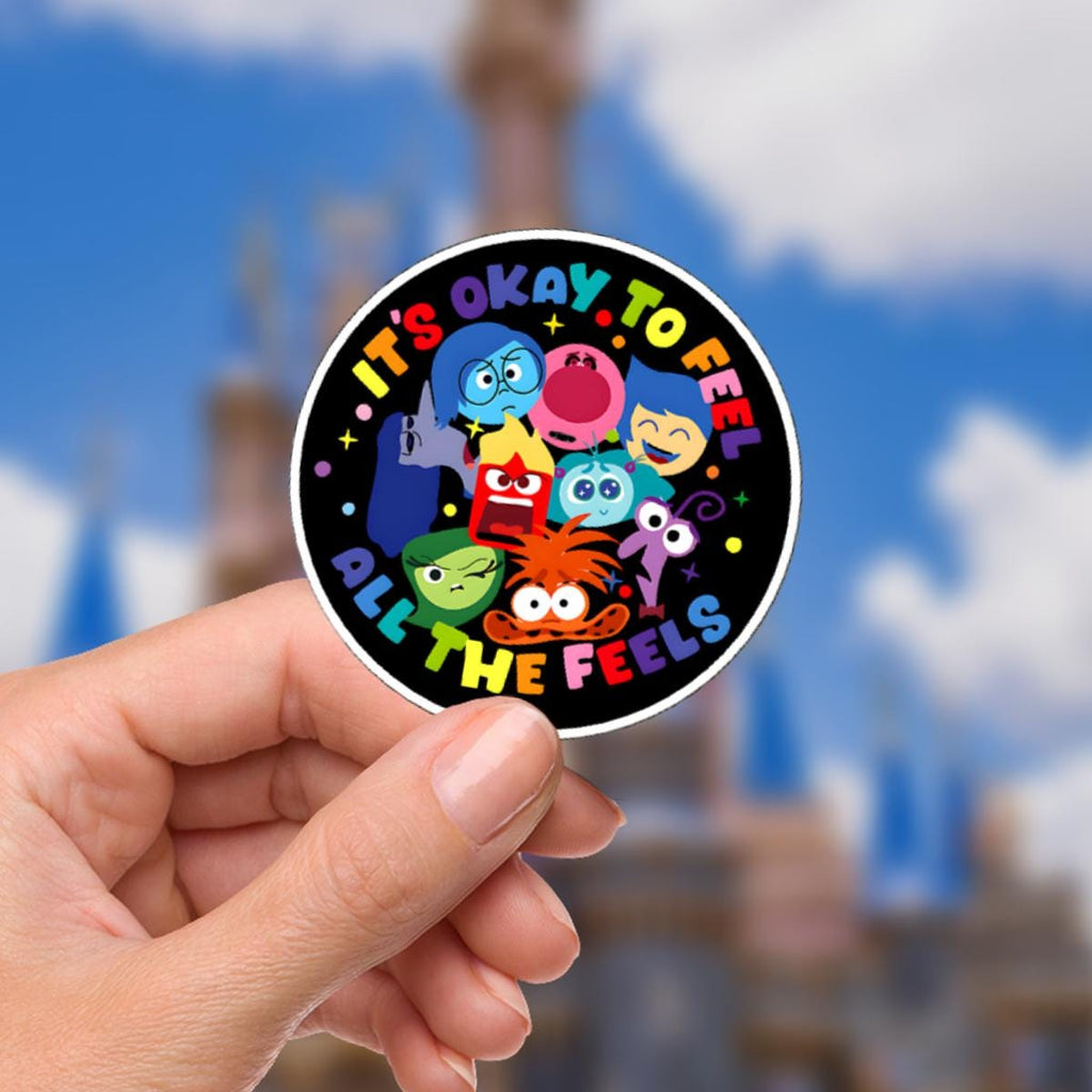 Inside Out Sadness Sticker: Waterproof Vinyl Decal Hydro Flask A round sticker featuring characters from the movie Inside Out. The sticker has a black background with the phrase 'It's okay to feel all the feels' in rainbow colors. The characters are depicted with various emotions, including joy, sadness, anger, fear, and disgust.